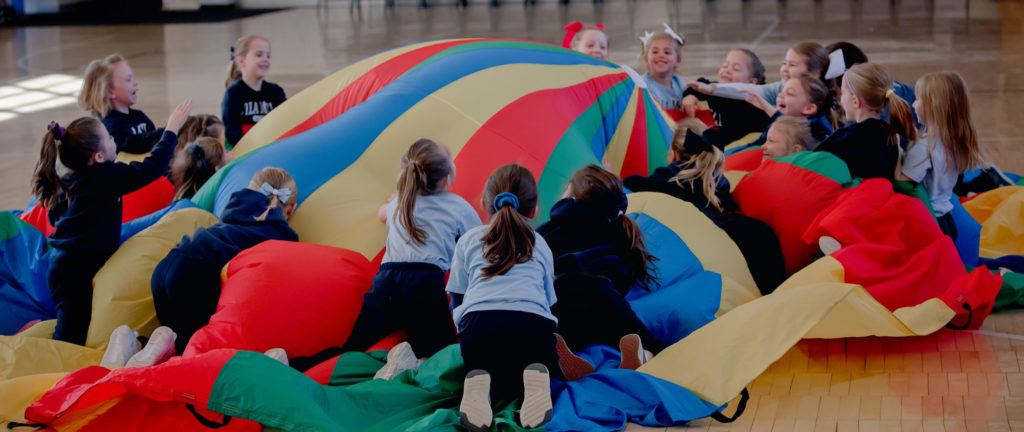 students climbing parachute